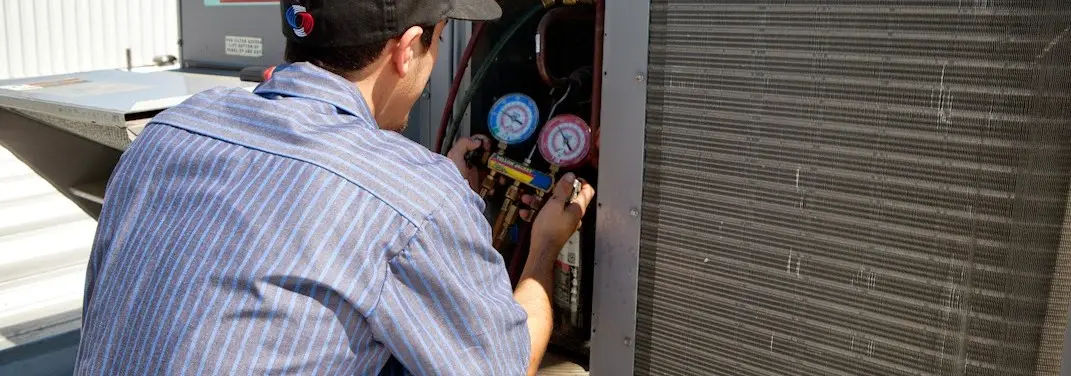 HVAC technician servicing a condenser unit in Brookshire
