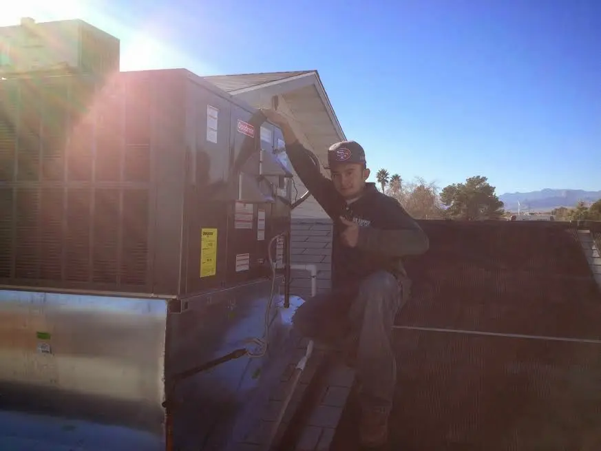HVAC technician performing Boiler Repair on a rooftop unit in Brookshire